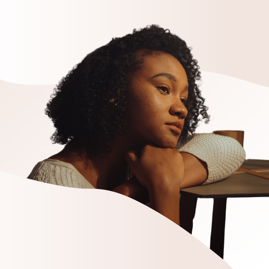 Someone leaning on a table with their head resting on their wrist.