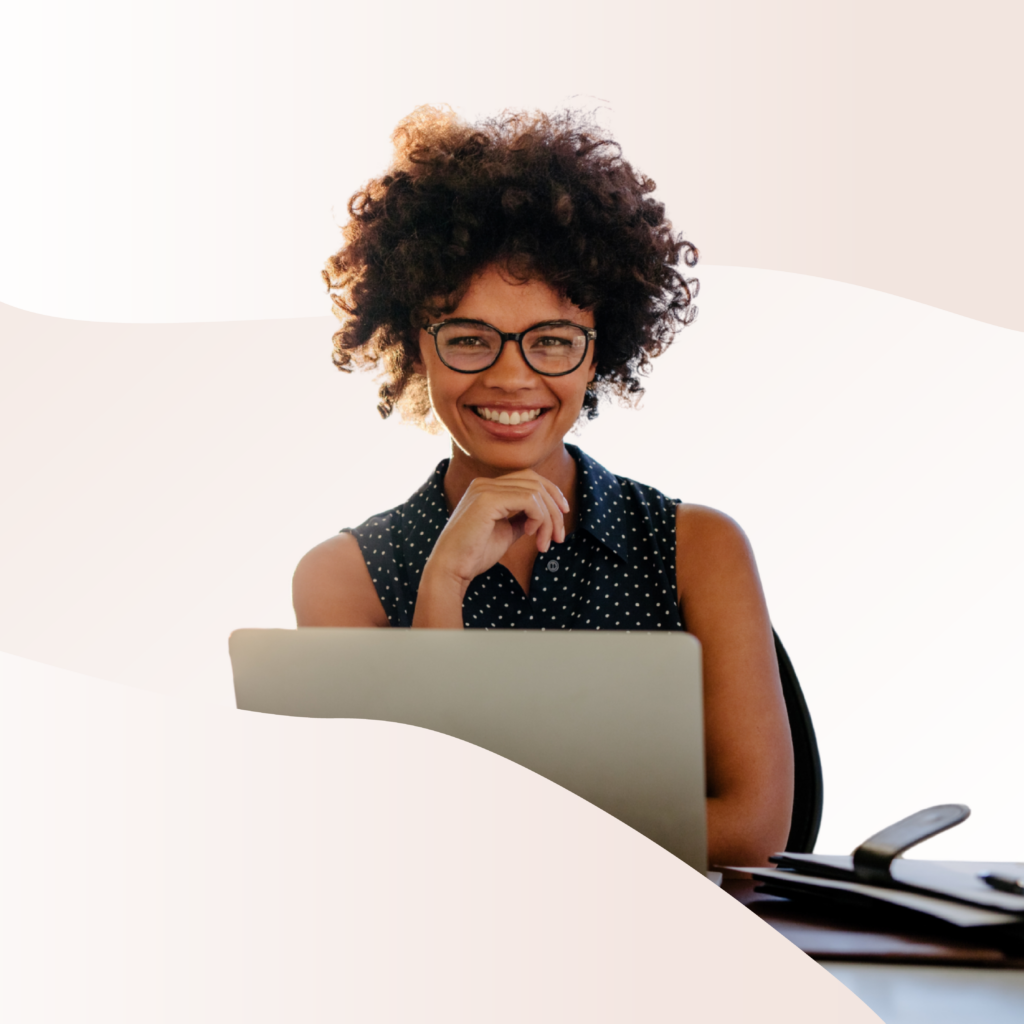 Someone smiling while working on a laptop