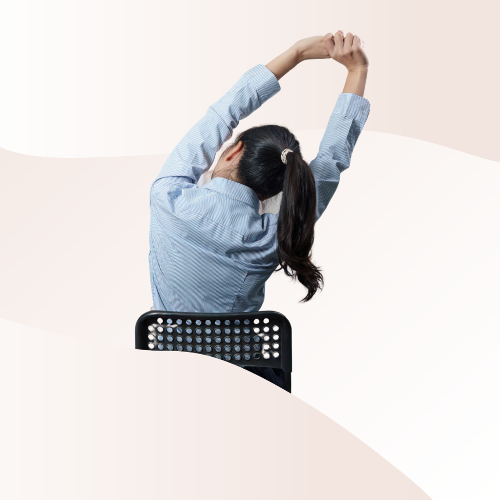 Someone sitting in a chair and reaching their arms over their head and to the right, giving their side a stretch.